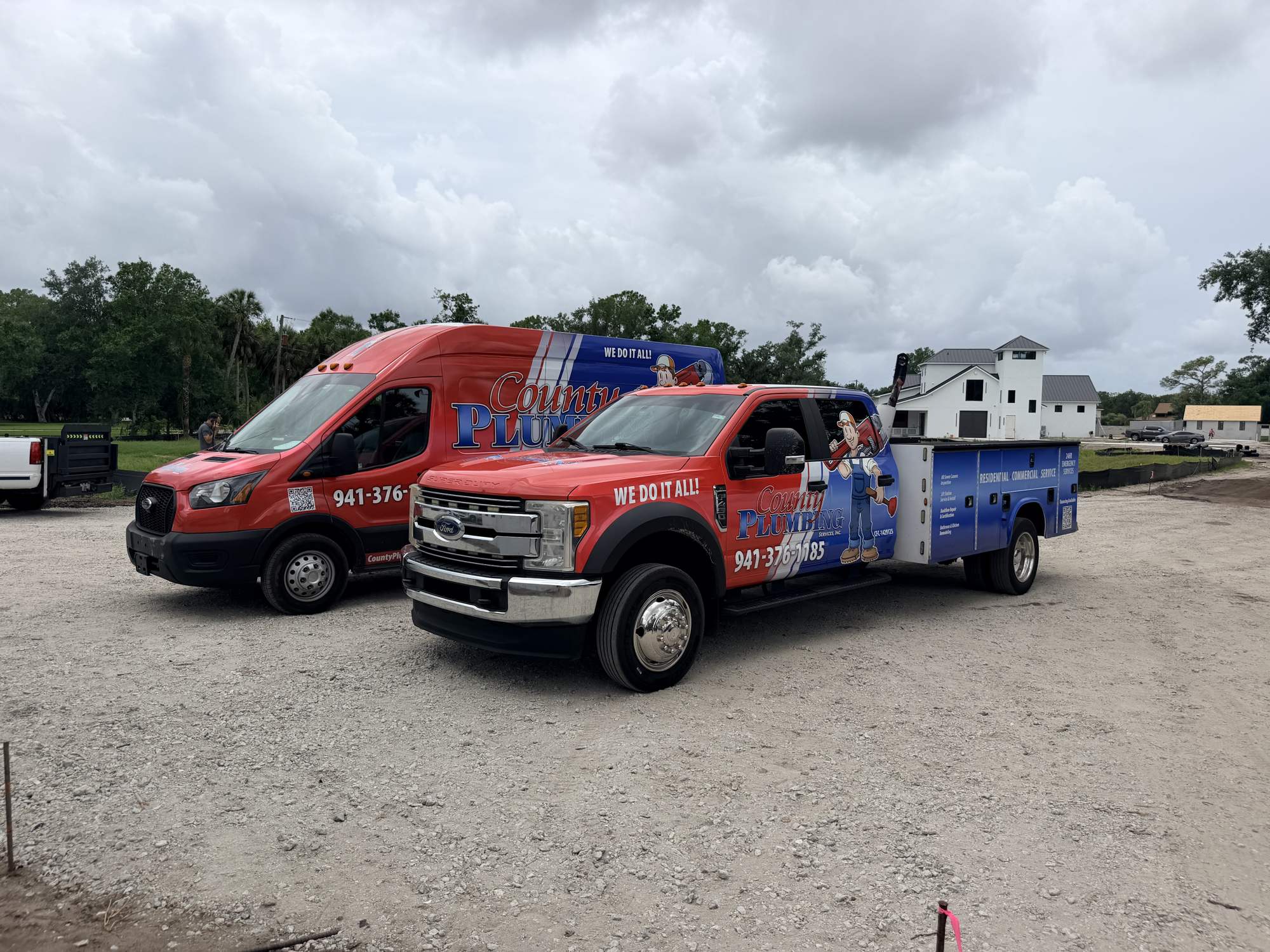 County Plumbing van and Ford F-550 service truck on a job site